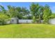 Manicured backyard featuring a storage shed, lush green lawn, and mature trees creating a private oasis at 476 Haines Trl, Winter Haven, FL 33881
