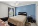 Bedroom featuring blue accent wall, ceiling fan, and window with natural light at 476 Haines Trl, Winter Haven, FL 33881