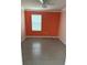 Empty bedroom has tile floors, orange walls and a window at 476 Haines Trl, Winter Haven, FL 33881