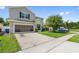 Home featuring a two car garage with screened in door and landscaping at 476 Haines Trl, Winter Haven, FL 33881