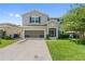 Front exterior featuring a two car garage with landscaping at 476 Haines Trl, Winter Haven, FL 33881