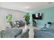 A cozy living room with tile floors, a large TV, and comfortable blue sofas at 476 Haines Trl, Winter Haven, FL 33881