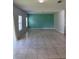 Spacious living room with neutral tile flooring and abundant natural light from large windows at 476 Haines Trl, Winter Haven, FL 33881