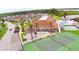 Aerial view featuring community amenities including tennis courts, a pool, and scenic lakeside views, surrounded by lush greenery at 492 Sweetwater Way, Haines City, FL 33844