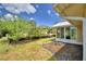 Landscaped backyard featuring a beautiful garden with blooming flowers and a sunroom with bright natural light at 492 Sweetwater Way, Haines City, FL 33844