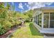View of backyard featuring a garden, sunroom, and greenery at 492 Sweetwater Way, Haines City, FL 33844