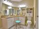 Bright bathroom features double sinks, granite countertop, vanity stool, and built in storage at 492 Sweetwater Way, Haines City, FL 33844