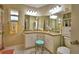 Bright bathroom features double sinks, granite countertop, vanity stool, and tiled floors at 492 Sweetwater Way, Haines City, FL 33844