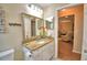 Bright bathroom featuring granite countertops, decorative mirror and fixtures, and coastal themed decor at 492 Sweetwater Way, Haines City, FL 33844