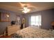 Well-lit bedroom with a decorative ceiling fan, blue walls, and a comfy seating area near the window at 492 Sweetwater Way, Haines City, FL 33844