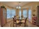 Bright dining room with large windows, vaulted ceilings, and a glass table at 492 Sweetwater Way, Haines City, FL 33844