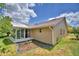 Back of home featuring a sunroom, well-kept lawn, and lush landscaping, creating a private outdoor oasis at 492 Sweetwater Way, Haines City, FL 33844