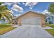 Single-story home with beige exterior, well-manicured lawn, and a two-car garage at 492 Sweetwater Way, Haines City, FL 33844