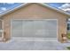 Beige single-story home with a large two car garage door at 492 Sweetwater Way, Haines City, FL 33844