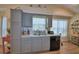 Charming kitchen boasts grey cabinets, granite countertops, and a window over the sink for natural light at 492 Sweetwater Way, Haines City, FL 33844