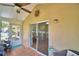Covered lanai featuring tiled flooring, ceiling fan, access doors, and comfortable wicker seating at 492 Sweetwater Way, Haines City, FL 33844