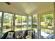 Enclosed lanai showcasing wicker furniture, tiled floor, and scenic backyard views through multiple windows at 492 Sweetwater Way, Haines City, FL 33844