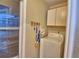 Convenient laundry area features a washing machine and upper cabinet storage at 492 Sweetwater Way, Haines City, FL 33844
