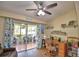 Bright room featuring a ceiling fan, laminate floor, desk, and sliding doors leading to a tiled lanai at 492 Sweetwater Way, Haines City, FL 33844