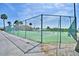 A fenced tennis court with scenic views in a serene community setting, providing a safe and enjoyable recreational space for residents at 492 Sweetwater Way, Haines City, FL 33844