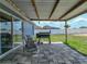 View of the covered back patio with tile pavers, outdoor furniture, a barbecue grill, and a large backyard at 541 Hatchwood Dr, Haines City, FL 33844