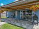 View of the back patio with tile pavers, outdoor furniture, a barbecue grill, and hanging flower baskets at 541 Hatchwood Dr, Haines City, FL 33844