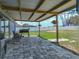 View of the back patio with tile pavers, barbecue grill, covered pergola, basketball hoop, and expansive backyard at 541 Hatchwood Dr, Haines City, FL 33844