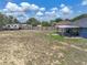 View of home's large backyard with a wooden fence and covered patio, offering ample space at 541 Hatchwood Dr, Haines City, FL 33844