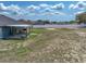 View of home's backyard with covered patio and sparse grass, showcasing outdoor living space at 541 Hatchwood Dr, Haines City, FL 33844