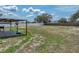 Vast backyard with sparse grass, basketball hoop, and covered patio, offering ample outdoor space at 541 Hatchwood Dr, Haines City, FL 33844