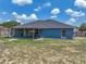 Back of home showing vast backyard with covered patio, grill, and sparse grass, ideal for outdoor activities at 541 Hatchwood Dr, Haines City, FL 33844