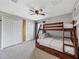 Neutral bedroom with a bunk bed, carpet, ceiling fan, closet, and a unique growth chart at 541 Hatchwood Dr, Haines City, FL 33844