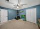Blue bedroom with toys, light carpet, and ceiling fan at 541 Hatchwood Dr, Haines City, FL 33844
