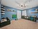 Blue bedroom with toys, dark carpet, and ceiling fan at 541 Hatchwood Dr, Haines City, FL 33844