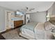 A cozy bedroom featuring a mounted TV, dresser, and a glimpse into the kitchen at 541 Hatchwood Dr, Haines City, FL 33844