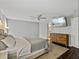 Bedroom features mounted TV, view to bathroom, and wood dresser at 541 Hatchwood Dr, Haines City, FL 33844