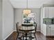 Cozy dining area with wood floors, round table, and white kitchen cabinets in a well-lit space at 541 Hatchwood Dr, Haines City, FL 33844