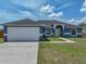 Charming blue single-story home featuring a well-manicured lawn and a bright yellow front door at 541 Hatchwood Dr, Haines City, FL 33844