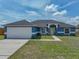 Charming blue single-story home featuring a well-manicured lawn and a bright yellow front door at 541 Hatchwood Dr, Haines City, FL 33844