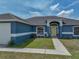 Eye-level shot of the front door with a sidewalk and Spring decor at 541 Hatchwood Dr, Haines City, FL 33844