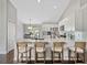 Bright kitchen featuring stainless steel appliances, white cabinetry, a center island with seating, and wooden floors at 541 Hatchwood Dr, Haines City, FL 33844