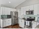 Modern kitchen with stainless steel appliances, white cabinets, and wood-look floors at 541 Hatchwood Dr, Haines City, FL 33844