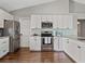 Modern kitchen with white cabinets, stainless steel appliances, and wood-look flooring at 541 Hatchwood Dr, Haines City, FL 33844
