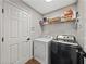 Functional laundry room with modern washer and dryer, plus shelving for storage at 541 Hatchwood Dr, Haines City, FL 33844