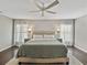 Bright main bedroom featuring hardwood floors, with ceiling fan, and bedside tables with matching lamps at 541 Hatchwood Dr, Haines City, FL 33844