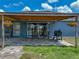 Covered patio with outdoor seating, brick flooring, and a grill overlooking the spacious backyard at 541 Hatchwood Dr, Haines City, FL 33844