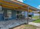 Covered patio with outdoor seating, brick flooring, and a grill overlooking the spacious backyard at 541 Hatchwood Dr, Haines City, FL 33844