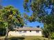 Residential backyard featuring a partial view of the home framed by mature trees at 5702 Breskin Dr, Orlando, FL 32839
