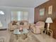 Cozy living room featuring plush seating, a glass coffee table, and natural light, ideal for relaxation at 5702 Breskin Dr, Orlando, FL 32839