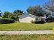 Well-maintained lawn with mature trees surrounding a single-story home, offering a serene outdoor setting at 5702 Breskin Dr, Orlando, FL 32839